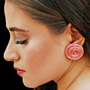 a woman wearing pink earrings