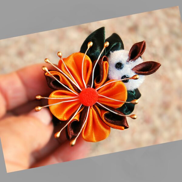 a hand holding bunny on a flower hair clip