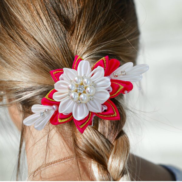 a woman wearing a red white flower hair clip