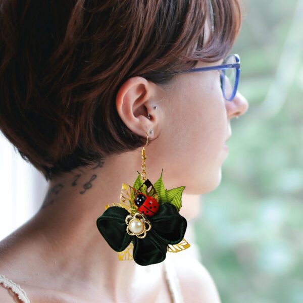 a woman wearing clover earrings