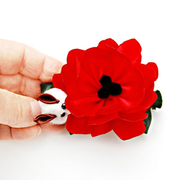 red poppy hair clip in a hand