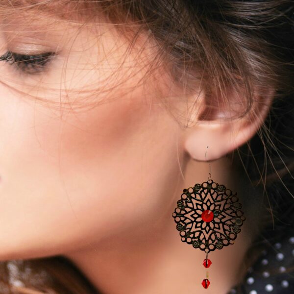 a woman wearing metal lace earrings