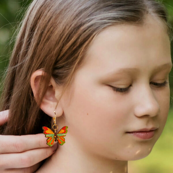 a girl wearing butterfly earrings