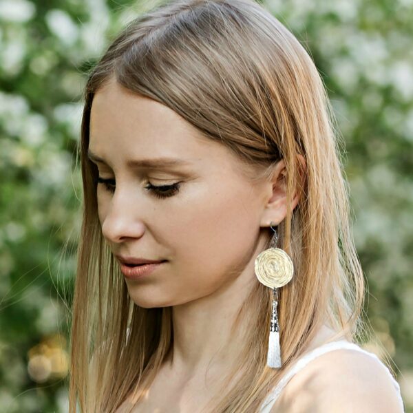 a woman wearing white tassel earrings