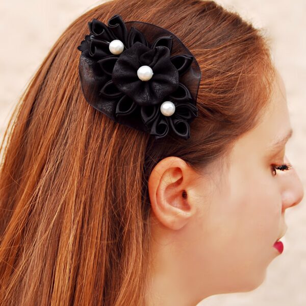 a woman wearing black flower hair clip
