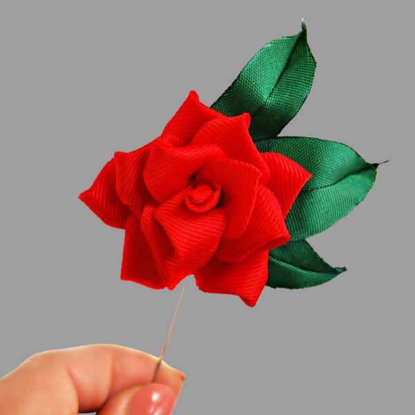 red rose lapel pin in a hand