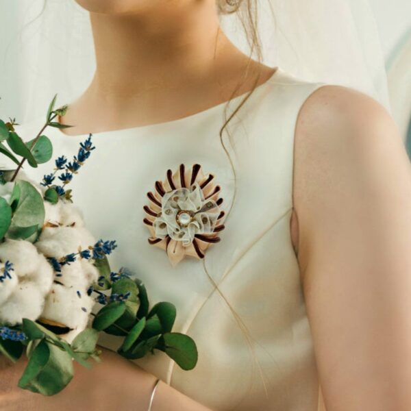 woman wearing a beige brooch