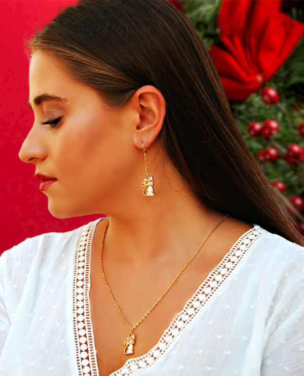 a woman wearing kitten earrings and a matching necklac