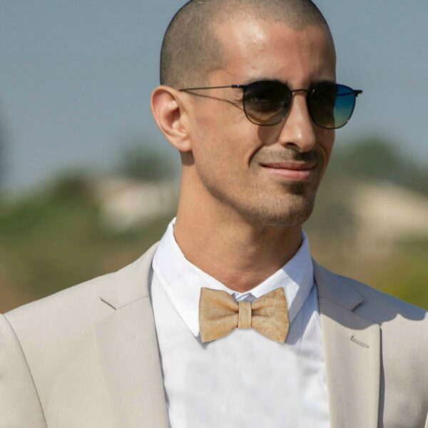 a man waering a nude color bowtie