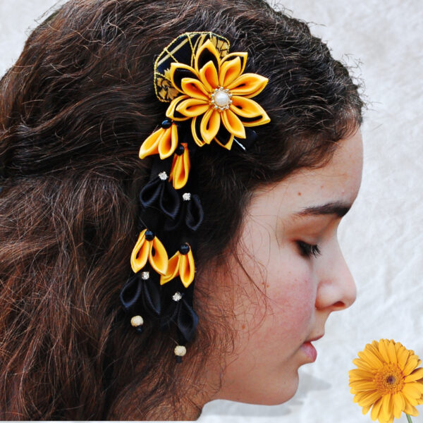 a girl wearing dangling black yellow hair clip