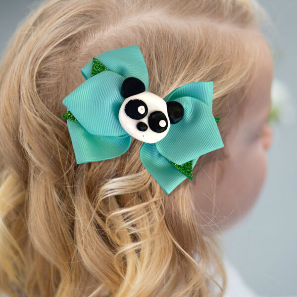 a girl wearing green panda bow